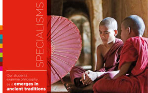 Our students examine philosophy Two young monks in red robes sat on the floor