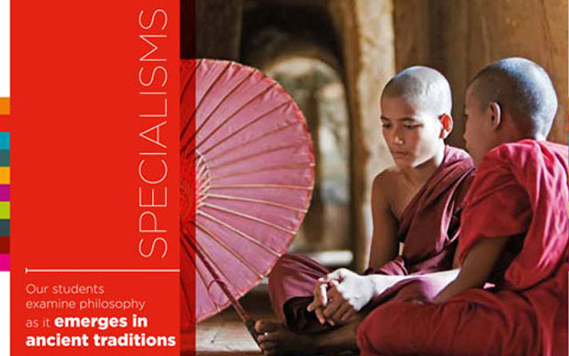 Our students examine philosophy Two young monks in red robes sat on the floor