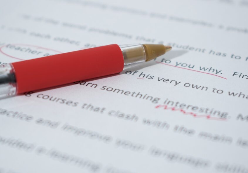 Red pen lying on piece of paper with text on it